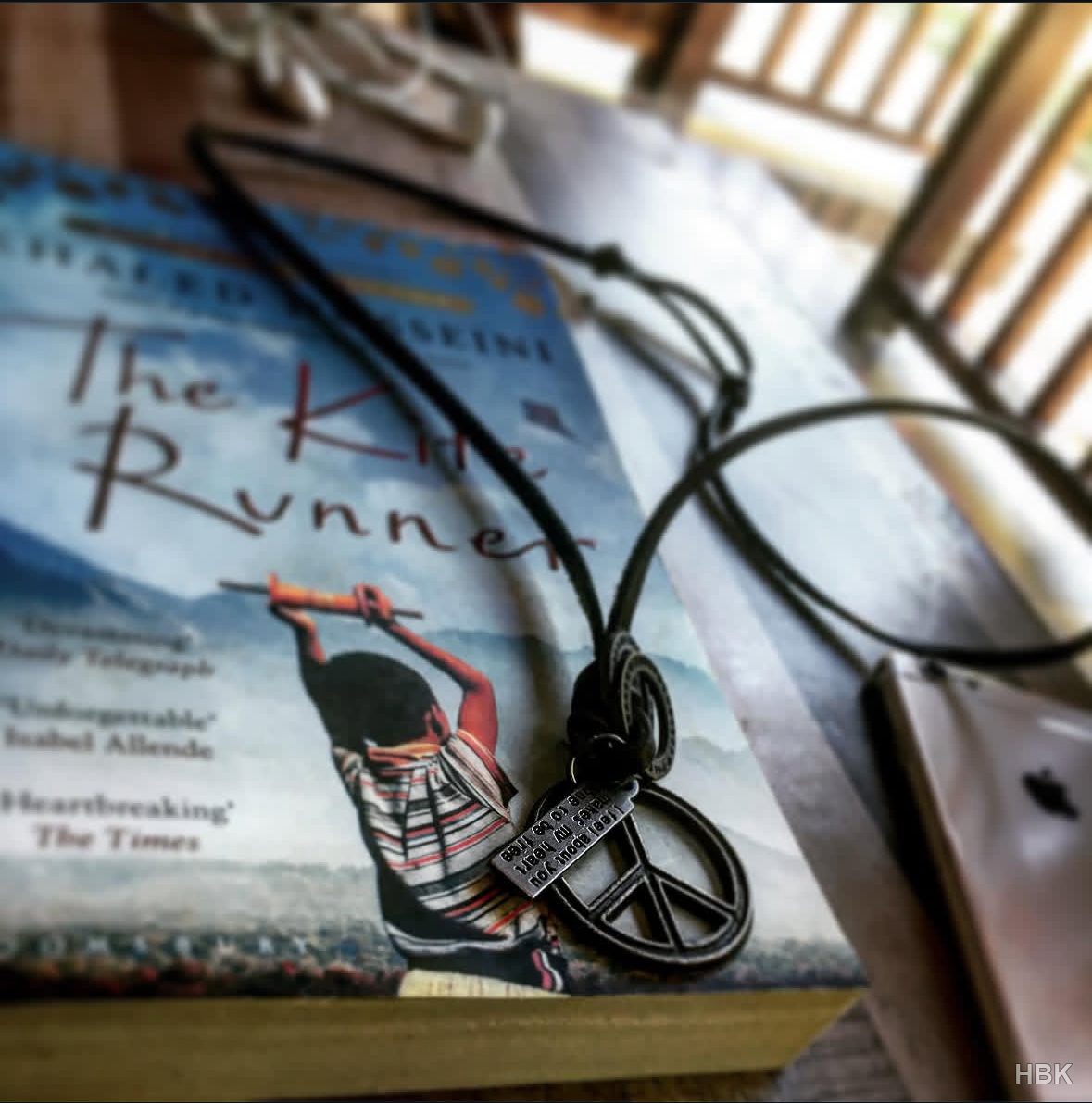 Pendant resting on a copy of The Kite Runner